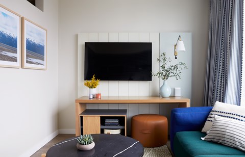 A living room with a black table and a blue couch.