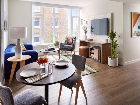 a living room with a table and chairs and a television