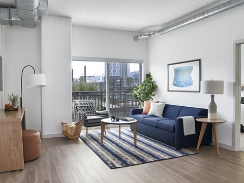 a living room with a blue couch and a large window