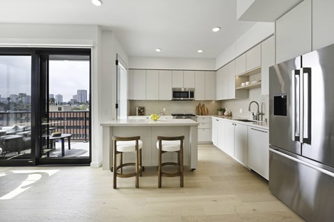 A modern kitchen with a large island and stainless steel appliances.
