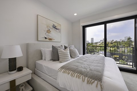 A bedroom with a large bed and a painting on the wall.