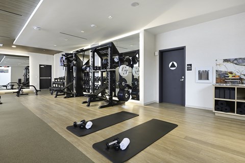 A gym with a variety of equipment including weights and exercise machines.