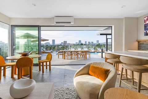 A modern rooftop lounge with a view of the Los Angeles skyline.