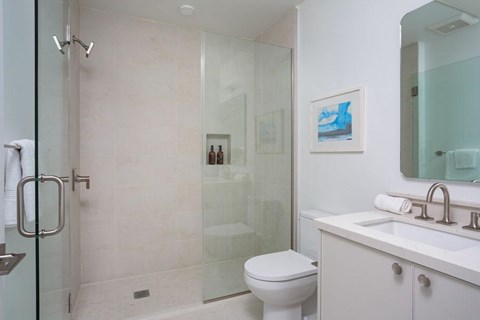 A bathroom with a toilet, sink, and shower.