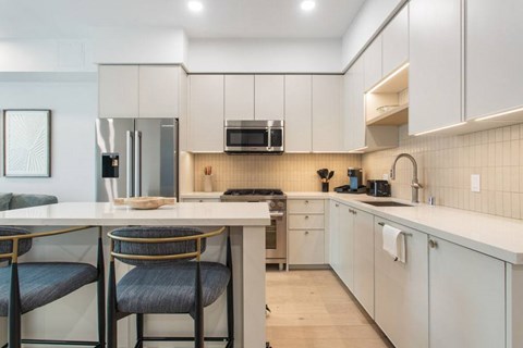 A modern kitchen with a center island and chairs at Ten310