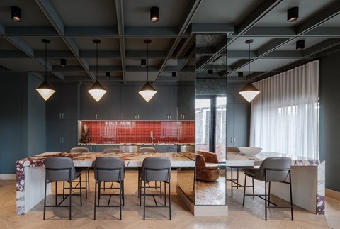 A modern dining room with a long table and chairs.