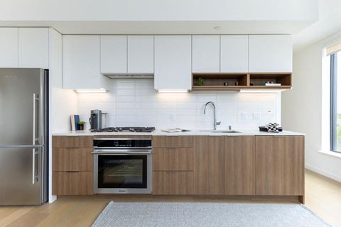 a kitchen with white walls and wooden cabinets