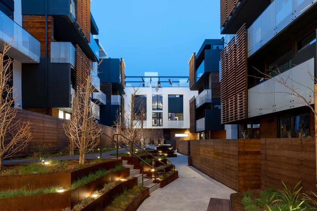 a row of modern apartments with a courtyard at night