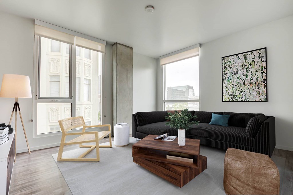 Open living room at Vance in San Francisco, CA.ch, wooden coffee table, and a large window.