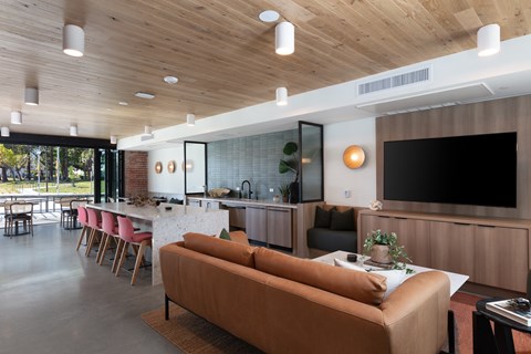 A modern living room with a brown sofa and a wooden ceiling.