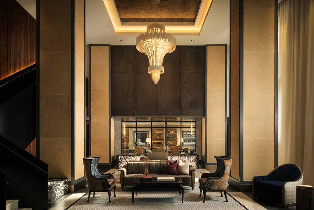 A large, elegant room with a chandelier and a variety of seating options.