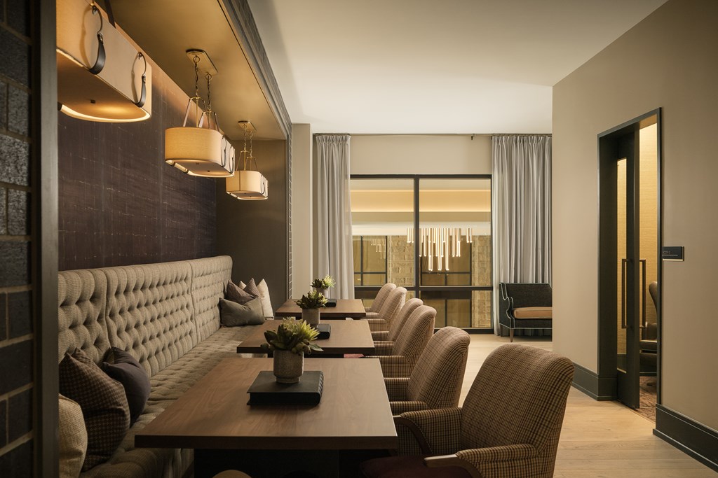 A long table with chairs and a plant on top is in the middle of a room.