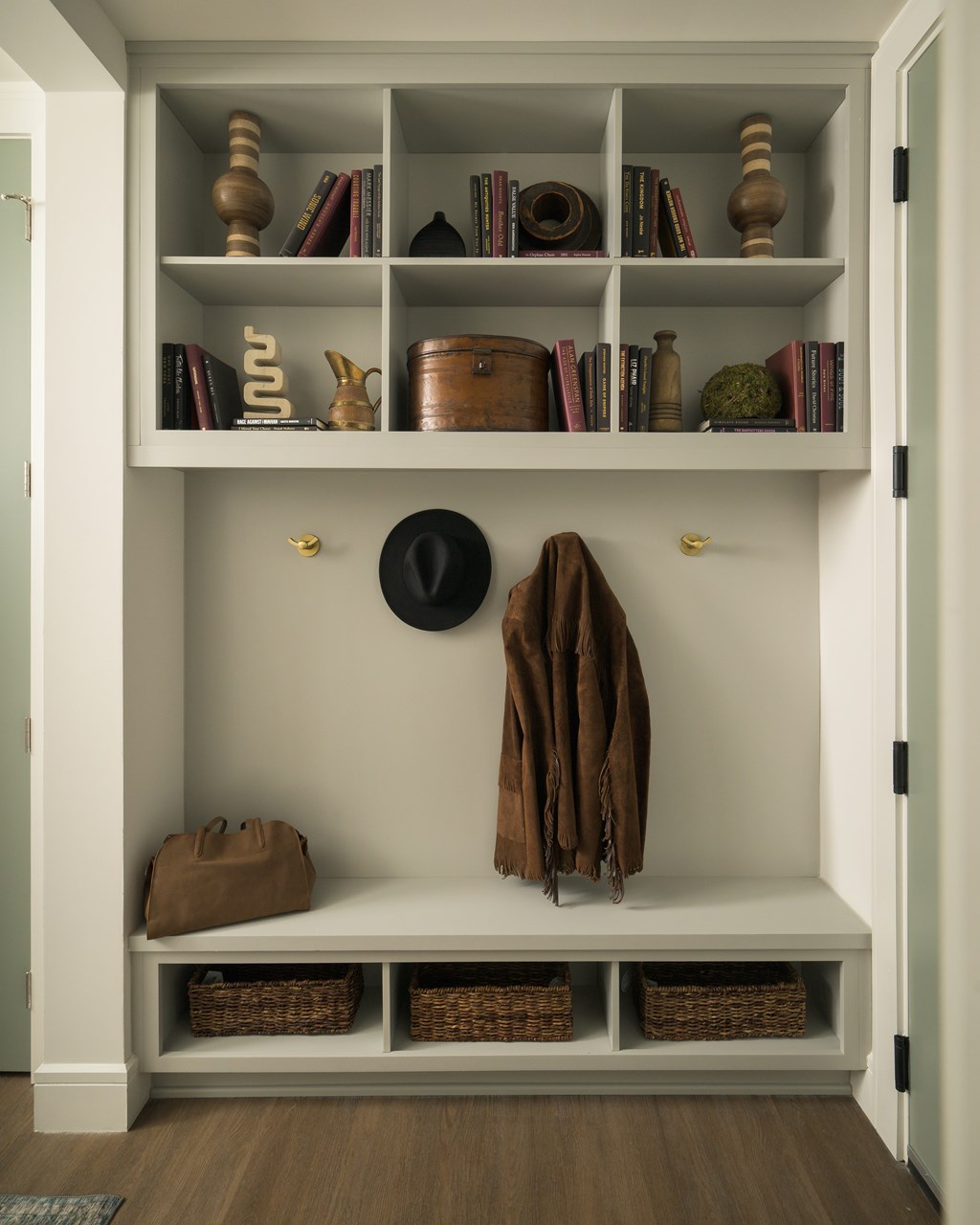 A white shelf with a coat hanging on it.