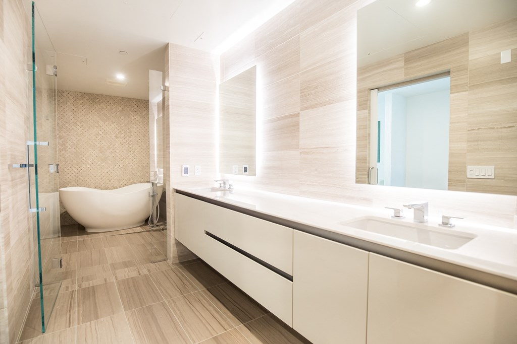 sleek full bath with tub and light neutral finishes