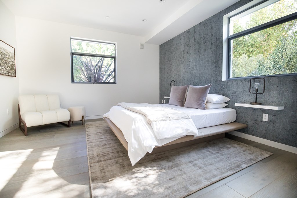 a bedroom with a bed and a chair in a 555 waverly unit