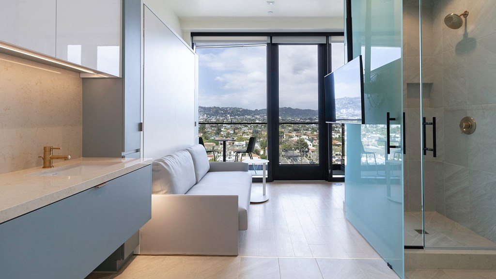 living room with stand up shower and tv Sentral Beverly Hills apartments