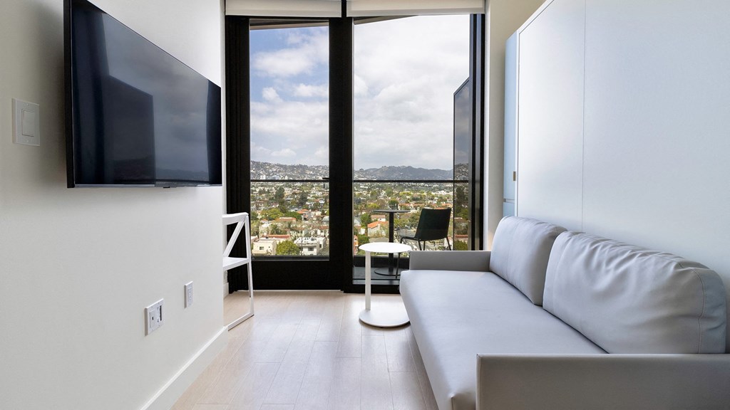 living room with flat screen tv and city views Sentral Beverly Hills apartments