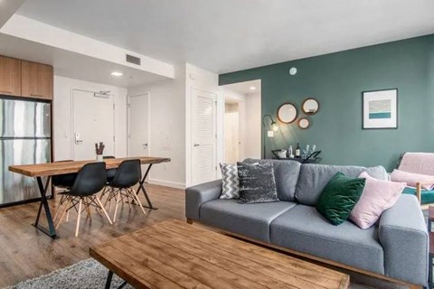 A modern living room with a grey couch and a wooden table.