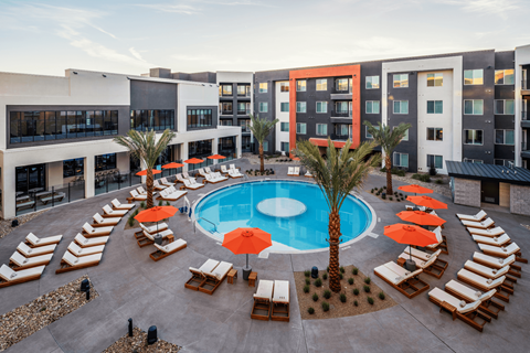 A pool surrounded by sun loungers and umbrellas.