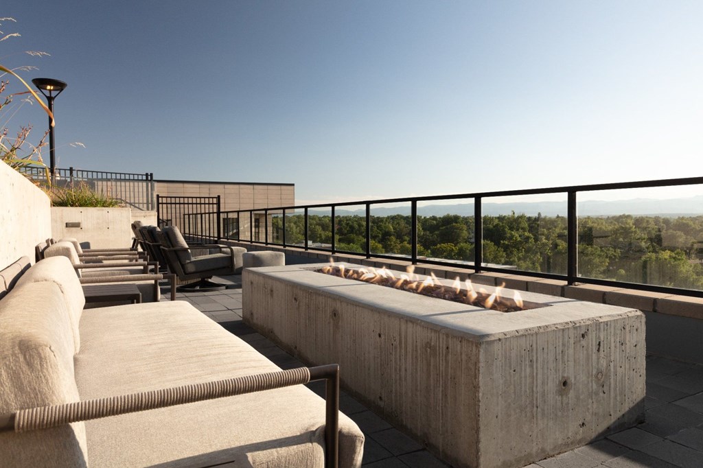 A concrete bench with a metal railing in front of a building.