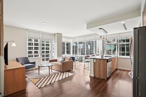 A modern kitchen and living room with a large window.