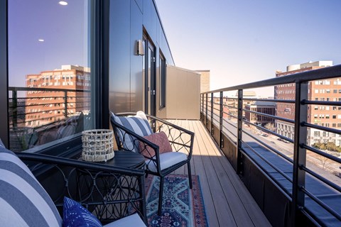 a balcony with a view of a city and a chair