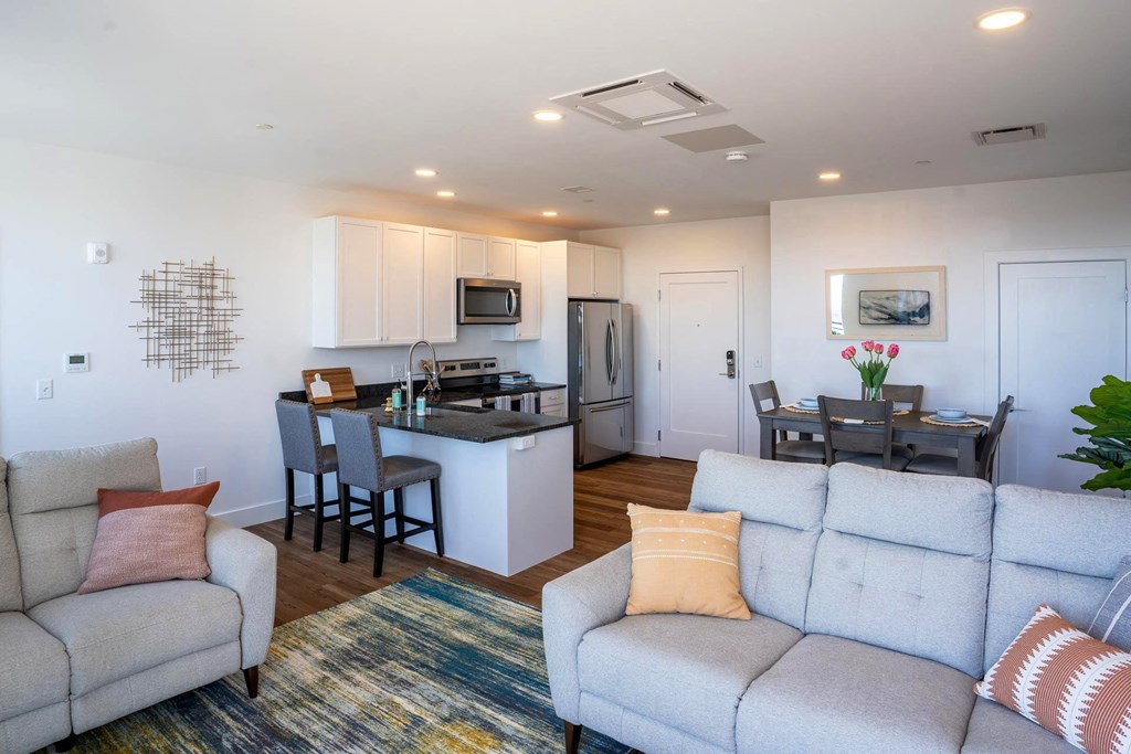 a living room and kitchen with a couch and a table