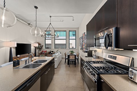 A modern kitchen with dark brown cabinets and stainless steel appliances.