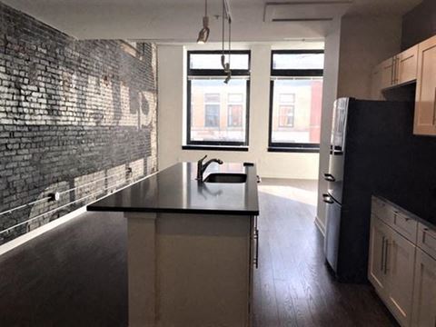 an empty kitchen with a black counter top