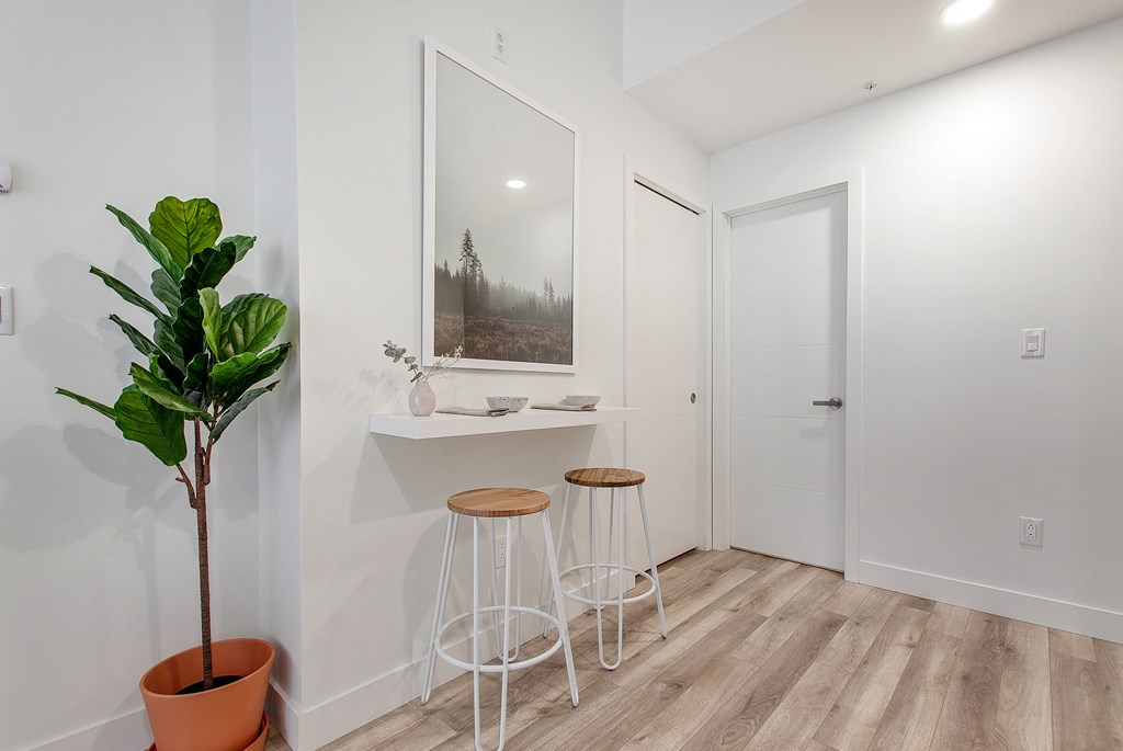 a room with two stools and a counter with a potted plant