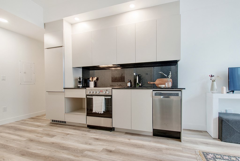 a kitchen with white cabinets and a stainless steel stove and refrigerator