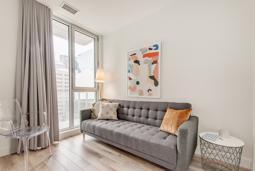 a living room with a gray couch and a large window