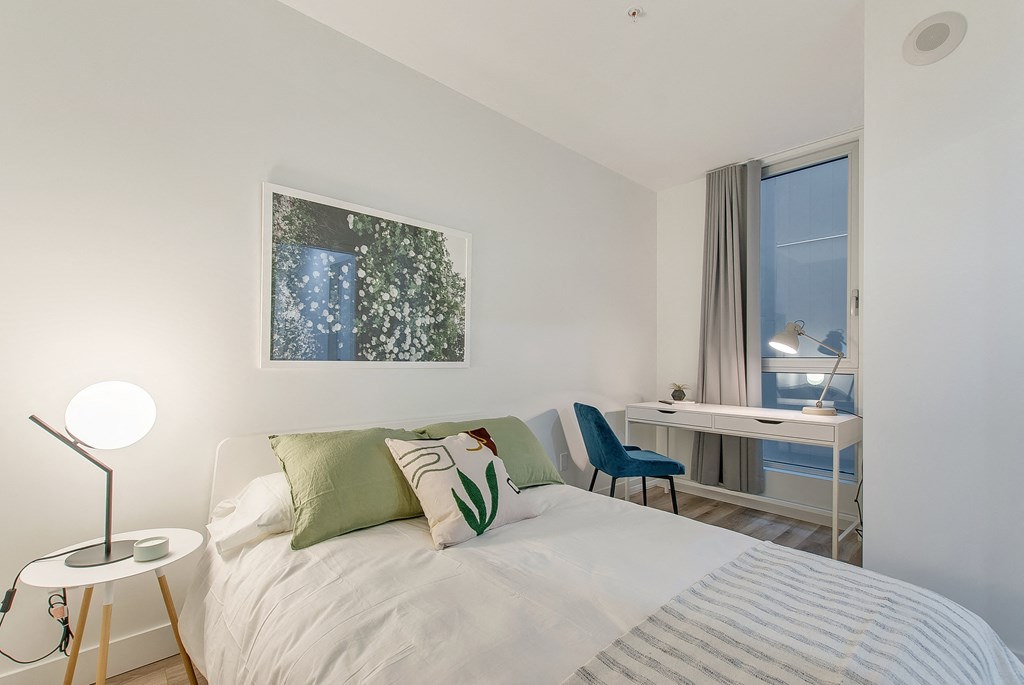 a bedroom with a bed and a desk with a chair