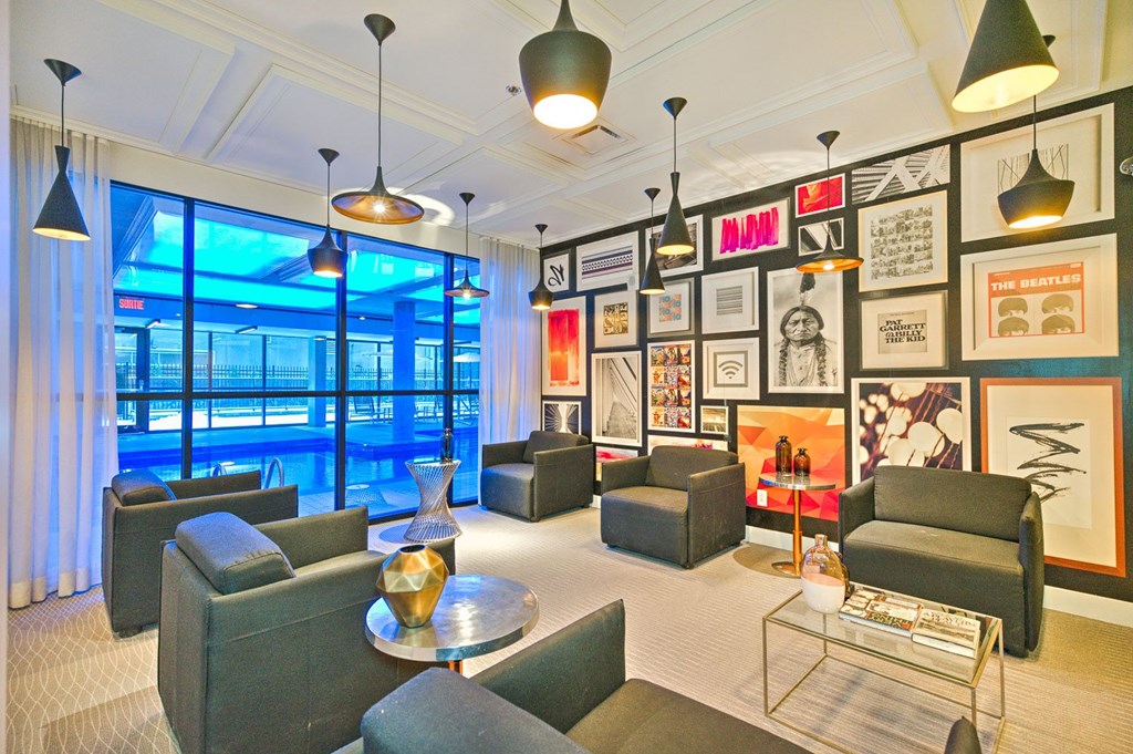 A living room with a large window and a pool outside.