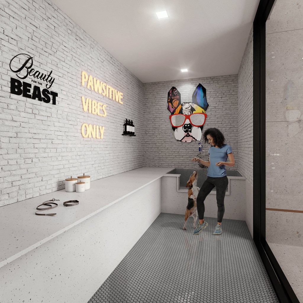 a woman playing with her dog in a bathroom with a sink and a mirror