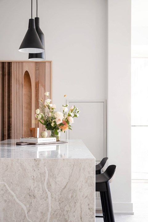 a kitchen with a marble counter top and black chairs
