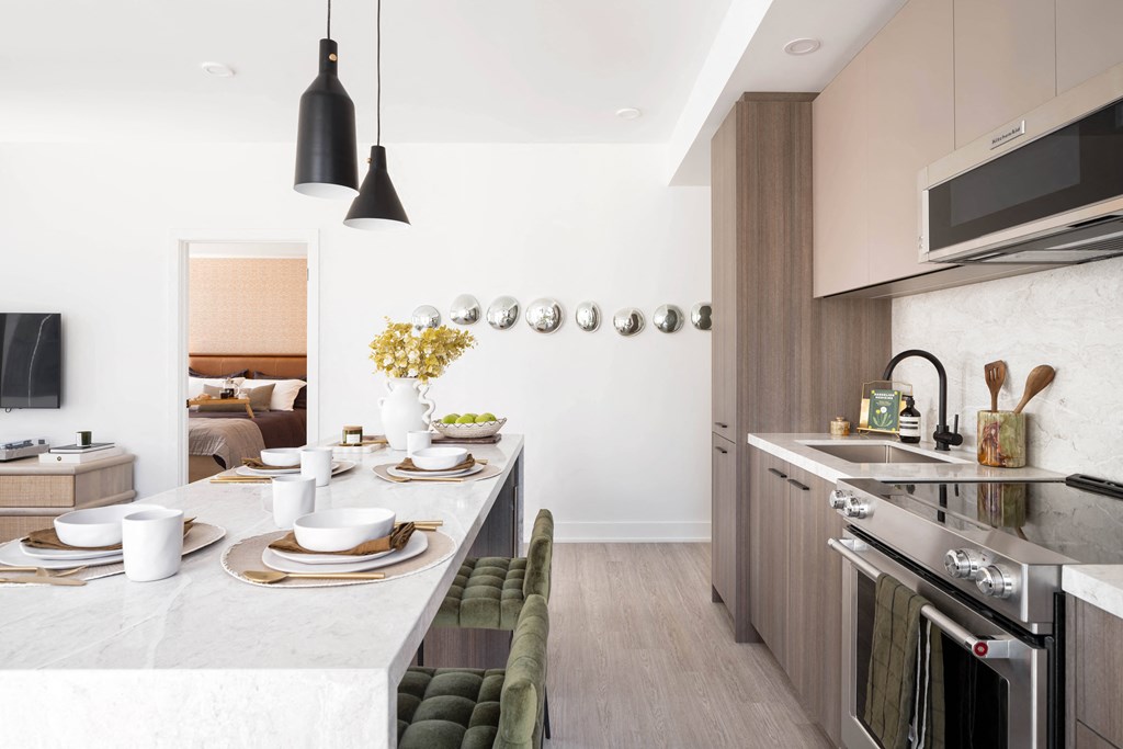a kitchen and dining area with a marble counter top and stainless steel appliances