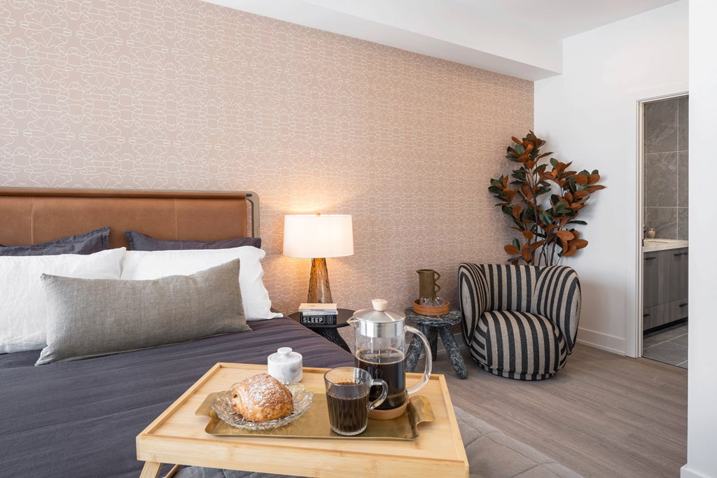 a bedroom with a bed and a coffee table with a tray of food