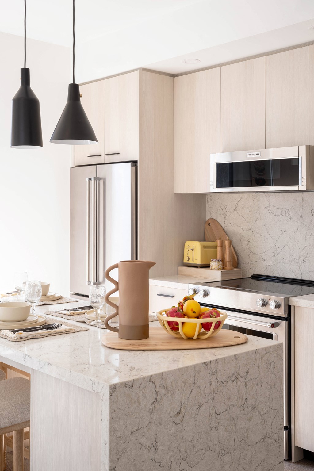 a kitchen with a marble counter top and a bowl of fruit