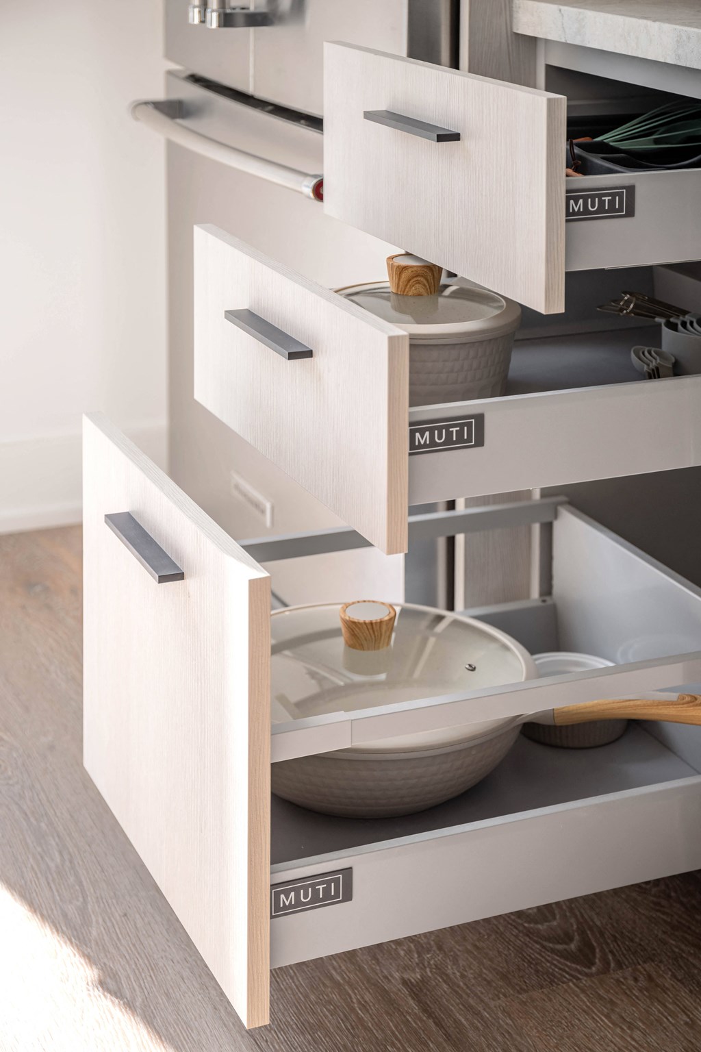 a kitchen with white cabinets and drawers and a drawer with a bowl in it