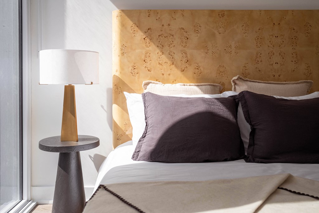 a bedroom with a bed and a table with a lamp