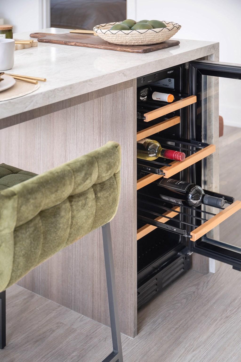 a kitchen with a wine refrigerator and a counter with a chair