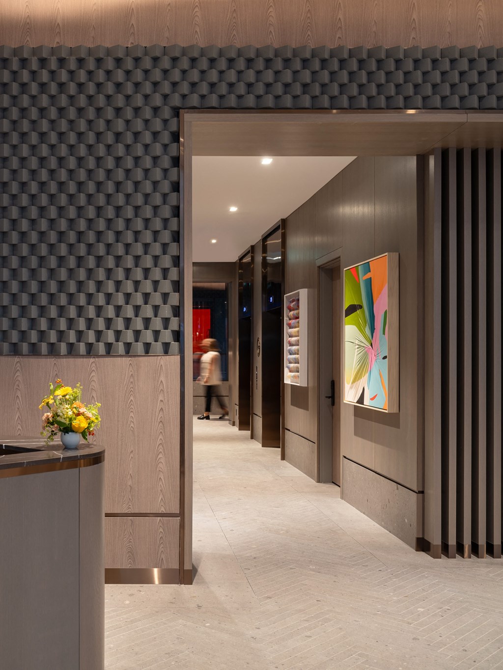 a view of a hallway with elevators and a painting on the wall