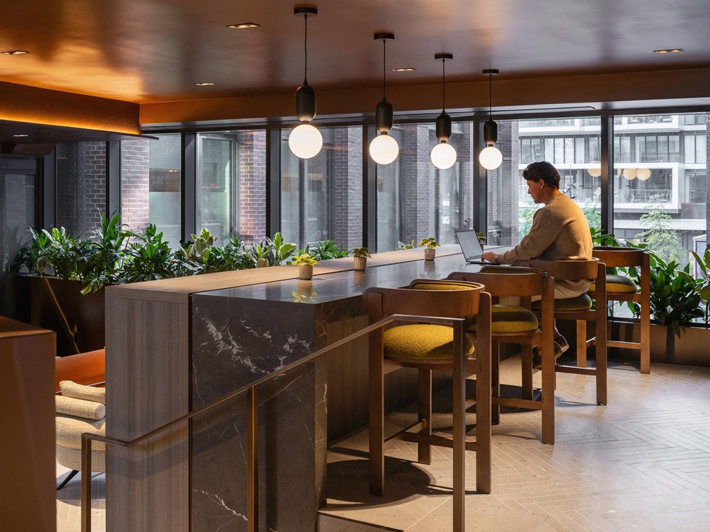 a man sitting at a bar in a restaurant with a laptop