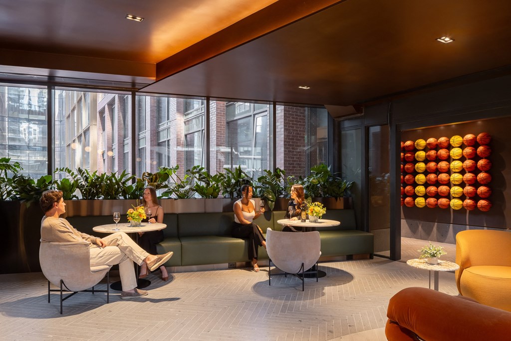 a group of women sitting in a lobby with couches and tables