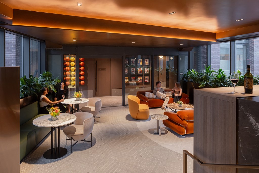 a lounge area with couches tables and chairs and a bar