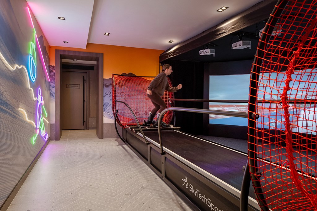 a young man riding a skateboard down a rail on a ramp in a room