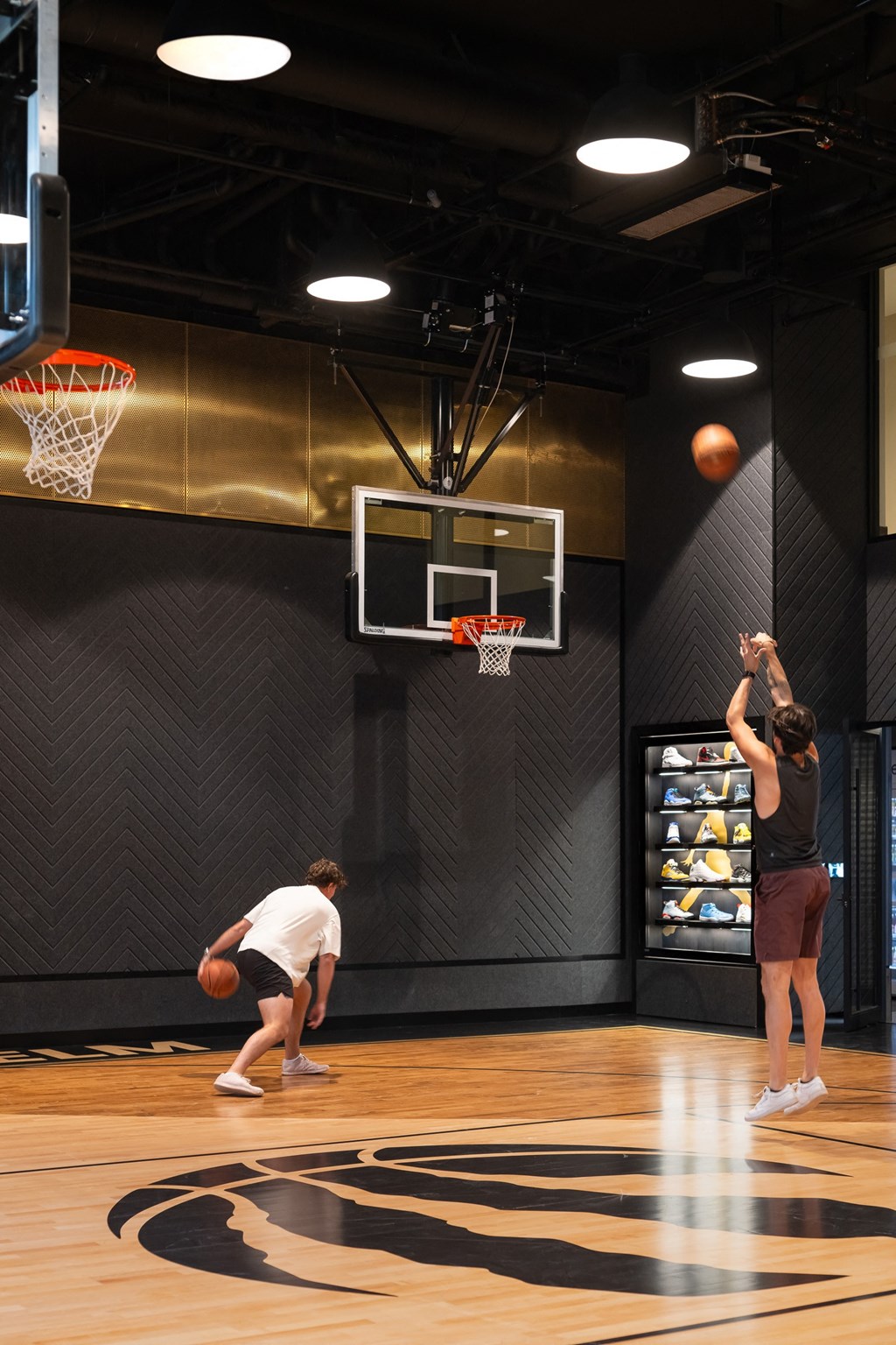 two people playing basketball in a gym with a ball