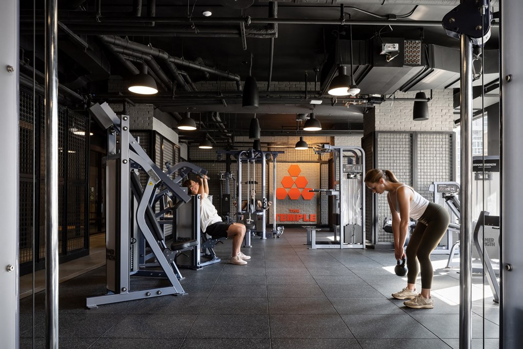 two people working out in a gym with weights