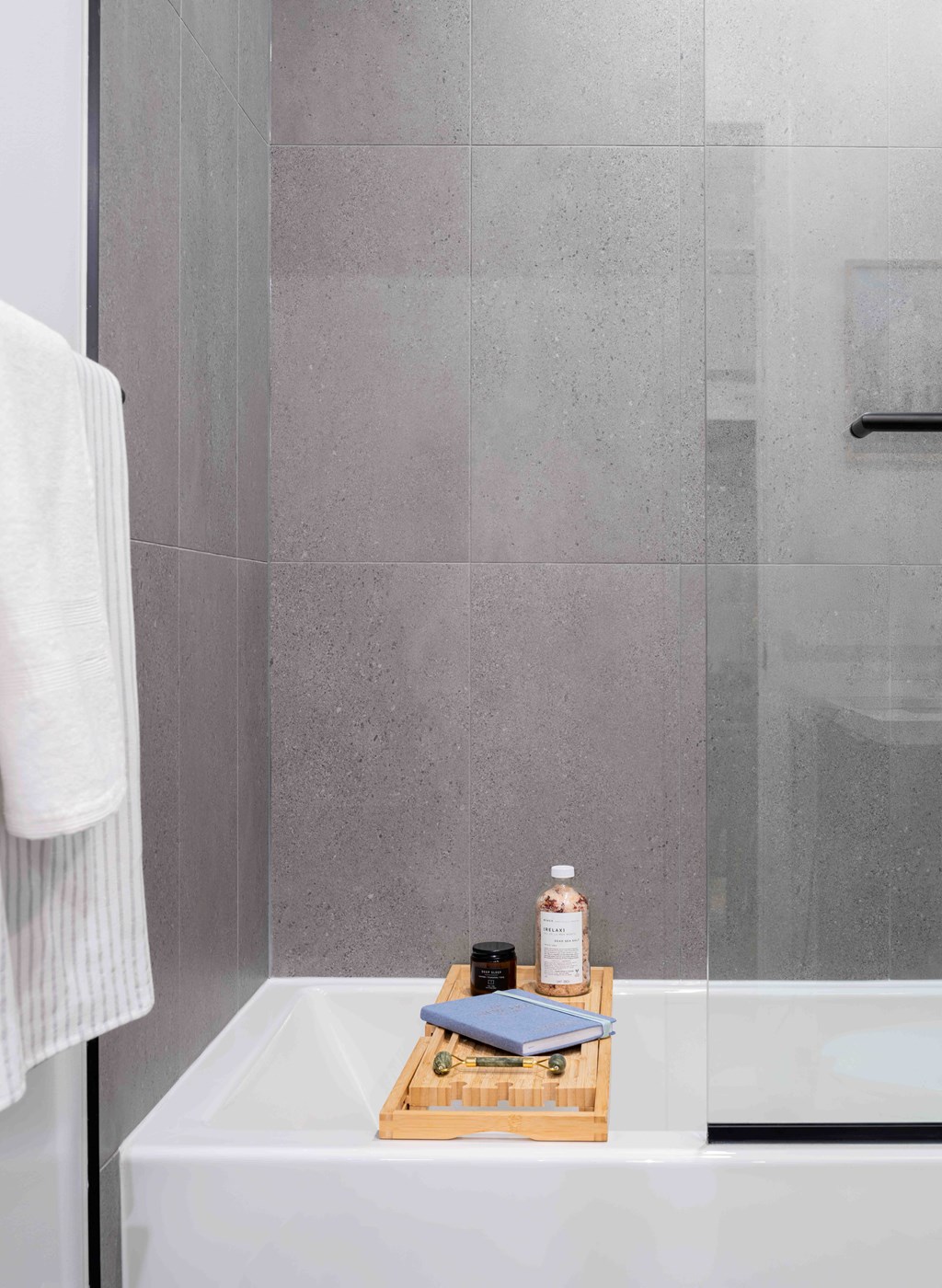 A white towel hangs on a rack in a modern bathroom.